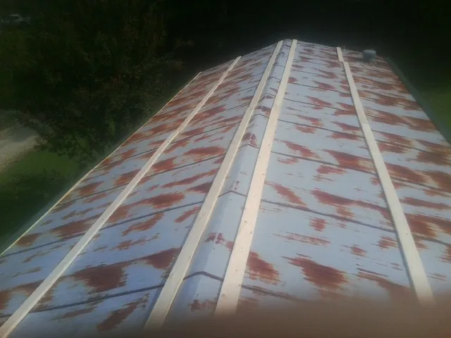 Rusted metal roof panels with new wood purlins before replacement — Storm Damage Roof Repair in Swansea by Roofing Brothers