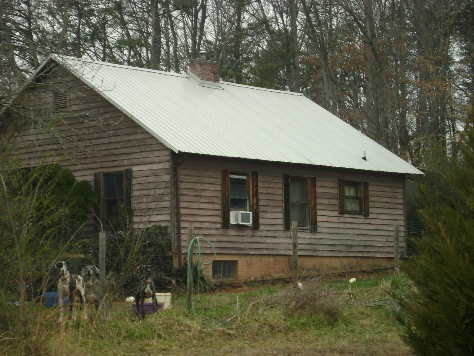 White metal roof on an old wood sided farmhouse, from a Metal Roof Installation job in Swansea